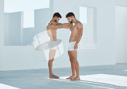 Image of Connection, gay and men touching arms for LGBTQ, power and creative contemporary art. Love, artistic and homosexual male couple or friends standing in underwear by a white open outdoor space.