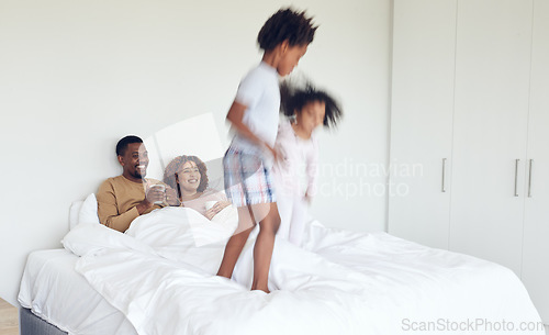 Image of Love, parents in bed and children jumping, quality time and happiness with bonding, home and cheerful. Family, energy and siblings with mother, father and kids playing in bedroom, joyful and morning