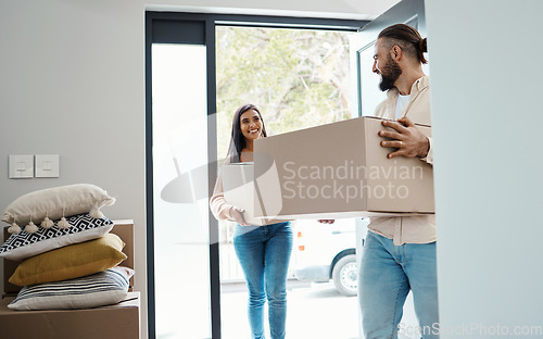Image of Couple moving, new house and carrying boxes with property, man and woman in real estate as homeowners. Mortgage, happy with move and walk in front door, partnership and people smile with relocation