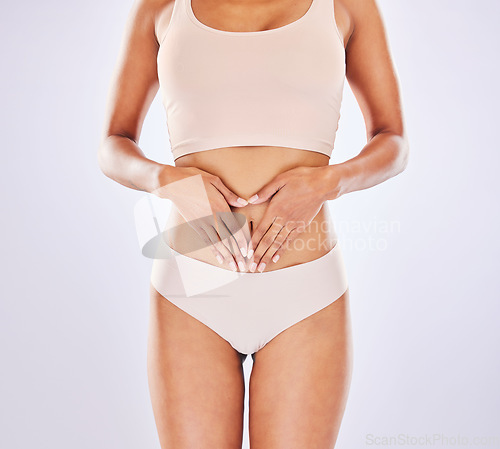 Image of Heart, body and hands on woman stomach in studio as motivation for weight loss, diet or fitness. Female on a white background with hand emoji for gut health, wellness and skin care in underwear