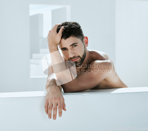 Image of Handsome, building and shirtless man outside in a modern bathroom for creativity and commercial model. Guy, body and artistic person relax, young and calm in a white room relaxing or chilling