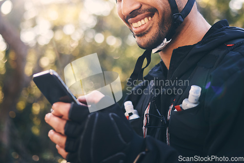 Image of Sports, man and phone outdoor for cycling, mountain biking or workout and smile in nature. Male person in forest with smartphone in hands for communication, gps travel app or fitness with safety gear