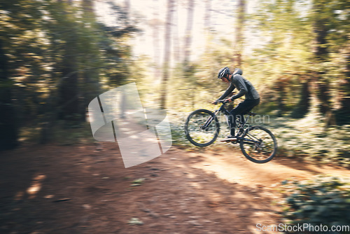 Image of Cycling, jump and fast with man in nature for adventure, fitness and extreme sports. Workout, exercise and speed with male cyclist on bike in forest park for action, performance and training