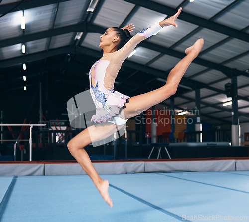 Image of Woman, gymnastics and jump for performance, flexible dance skill and sports competition. Female, rhythmic movement and stretching body in action, creative talent and motion with agility in arena show