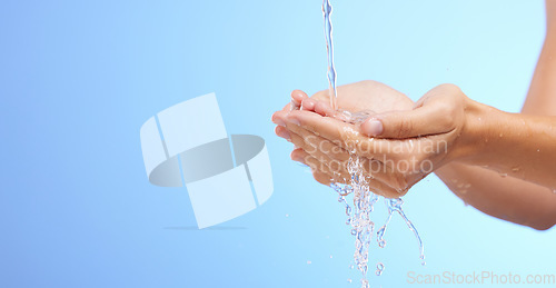 Image of Water splash, woman or cleaning hands in studio on blue background for wellness or skincare hydration. Mockup space banner, palm or girl with liquid splash hand wash in hygiene or bacteria prevention