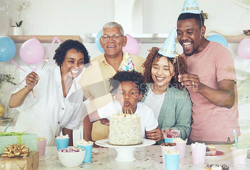 Image of Birthday party, cake and blow with family in kitchen for celebration, bonding and affectionate. Happiness, excited and grandparents with parents and child at home for surprise, fun and event