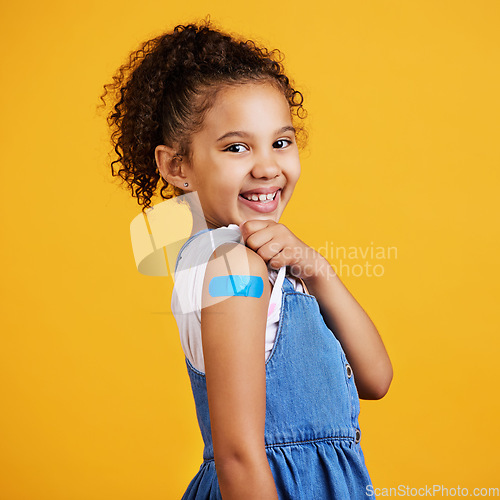 Image of Portrait plaster and girl with smile, confidence and vaccination against a studio background. Face, Latino female child and happy young person showing injection, happiness and cheerful on backdrop
