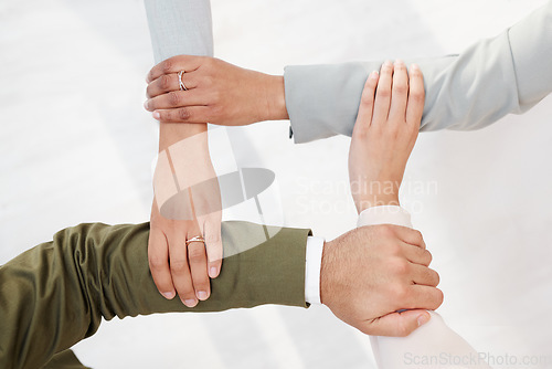 Image of Business people, hands together and unity in teamwork, collaboration or meeting for community trust above at office. Hand of group employee touching arms in team building, agreement or coordination