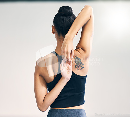 Image of Fitness, back and woman arm stretch in studio for yoga, exercise or training on grey background. Pilates, stretching and behind girl personal trainer at sports center for wellness, workout or warm up