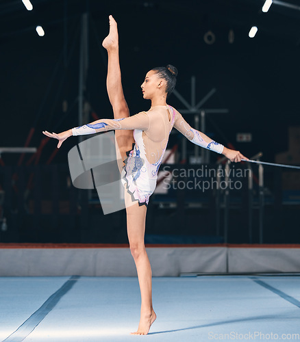 Image of Ribbon, gymnastics and flexible woman in dance performance, balance legs and sports competition. Female, rhythmic movement and flexible dancing athlete, action and talent of creative concert in arena