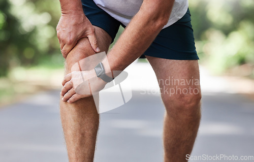 Image of Running, knee pain and old man with hand on leg in park in for outdoor fitness and workout exercise. Health, wellness and muscle strain, senior runner with injury, hands on ache in support or relief.