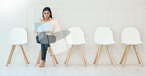 Image of Waiting room, sitting and a woman with a laptop for business, email and interview research. Office, working and corporate employee with a computer for the internet, recruitment planning and browsing