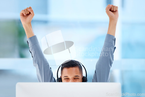 Image of Happy, success and a man in call center with a win, celebration and target achievement on a pc. Smile, excited and a customer support agent celebrating a promotion, bonus or telemarketing goal