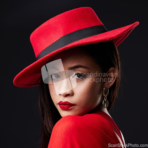 Image of Portrait, red and fashion with a woman on a dark background in studio rich or wealthy style. Face, elegant and classy with an attractive young female model posing in modern designer clothes