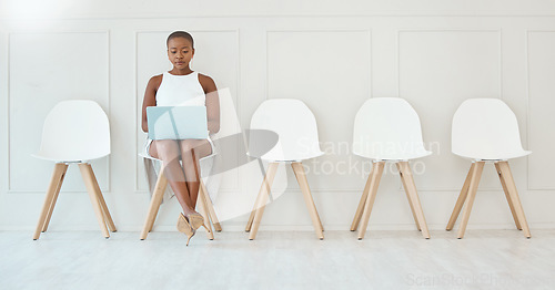 Image of Laptop, black woman and waiting room chair for job interview, recruitment or hiring. Computer, hr and serious business person typing or African female sitting in office for employment in workplace.