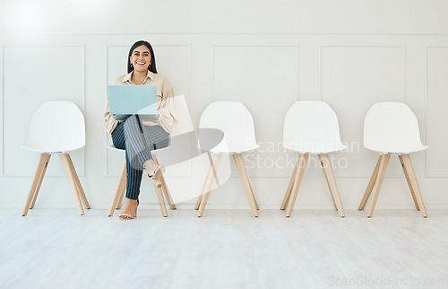 Image of Portrait, laptop and woman in waiting room, interview or recruitment, hiring or office job. Computer, hr and happy business person or female from India sitting on chair for employment in workplace