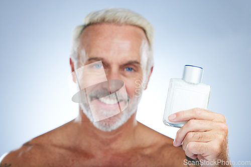 Image of Old man, cologne aftershave and portrait in a studio with perfume and spray bottle product with a smile. Isolated, grey background and happiness of a senior and elderly model with beauty routine