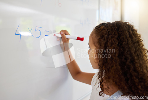 Image of Whiteboard, math and girl writing for learning, studying and education in classroom. Development, mathematics and kid or student write equations, numbers and multiplication for knowledge in preschool