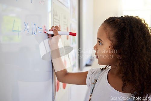 Image of Whiteboard, math and girl writing for learning, studying and education in classroom. Development, mathematics and kid or student write equations, numbers and multiplication in elementary school.