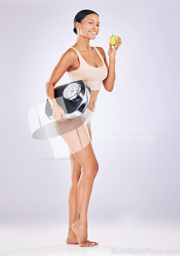 Image of Body, health and woman with scale, apple and fitness against a white studio background. Face, female or portrait with diet, training or workout with wellness, goals or target with nutrition and smile