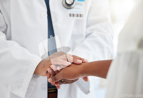 Image of Healthcare, hands and doctor comforting a patient after a diagnosis at a consultation in the hospital. Wellness, compassion and male medical worker with empathy for a woman in a medicare clinic.