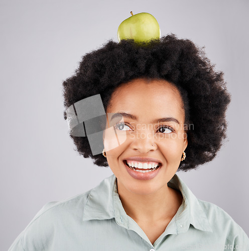 Image of Thinking, apple on head and black woman with smile, health and nutrition against a grey studio background. African American female, fruit and happy lady with happiness, diet and wellness with ideas