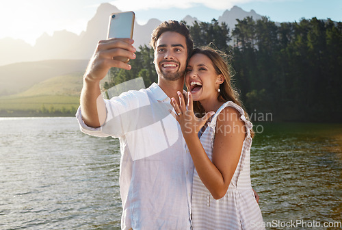 Image of Couple, nature selfie and engagement by lake for celebration, happiness and excited for future. Man, woman and photography for social media, profile picture and romance with love, proposal and goals