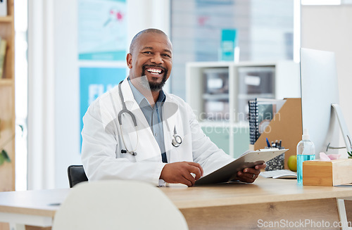 Image of Healthcare, portrait and black man doctor in his office with a clipboard to analyze test results. Success, smile and professional African male medical worker working on a diagnosis in medicare clinic