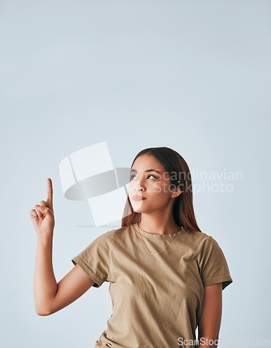 Image of Idea, thinking and a pointing woman with space isolated on a white background in a studio. Direction, mockup and a girl gesturing for a plan, contemplation or a decision on a backdrop or wall