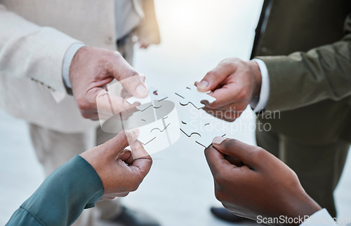 Image of Hands, puzzle or collaboration with a business team closeup in an office for planning from above. Teamwork, strategy and jigsaw pieces with a group of employee people or colleagues working in synergy