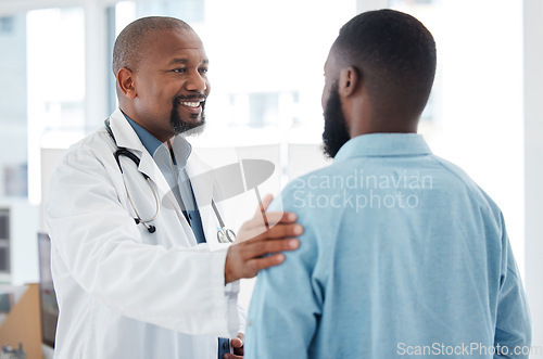 Image of Doctor, black man and touch shoulder of patient for support, comfort and empathy in hospital. Healthcare, consultation and happy medical professional talking, good news or kindness with mature person