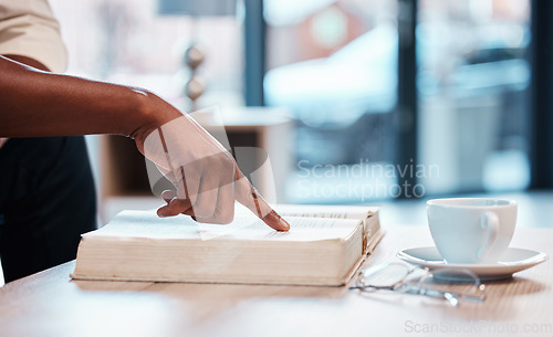 Image of Hand, bible and a person reading in a cafe for religion, belief or faith in god and jesus. Education, learning and pointing with an adult in a coffee shop to study for spiritual knowledge in christ