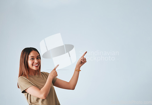 Image of Woman, pointing hands and smile at space for mockup, studio advertising or product placement. Happy female on white background to show logo or branding with discount, promotion or sale announcement