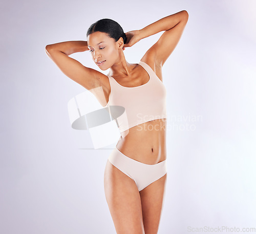 Image of Beauty, underwear and body with a model woman in studio on a gray background to promote skincare. Natural, wellness and health with an attractive young female posing in lingerie for hair removal