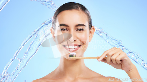 Image of Portrait, water splash or happy girl brushing teeth with product for healthy oral or dental hygiene in studio. Face, smile beauty or woman model cleaning mouth with a natural bamboo wooden toothbrush