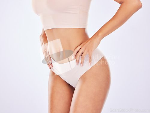 Image of Woman, body and stomach for healthy lifestyle in studio as motivation for weight loss, diet or fitness. Female on a white background with hand on waist for health, wellness or skin care in underwear
