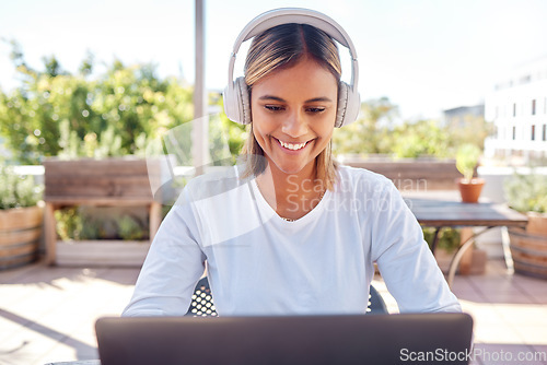 Image of Woman, laptop and headphones, student and education with smile, study and online course, elearning and university. Female at outdoor cafe, writing thesis and listen to music with research for paper