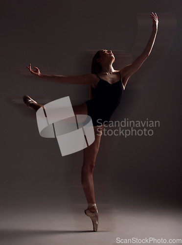 Image of Flexibility, dance and woman in the dark for ballet isolated on a black background in a studio. Creative, elegant and dancer dancing for a theater performance, rehearsal or ballerina movement