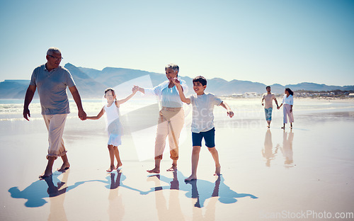 Image of Beach, family holding hands and grandparents with children playing and walking on ocean sand together. Fun, vacation and senior man and woman with kids bonding, quality time and summer walk in nature