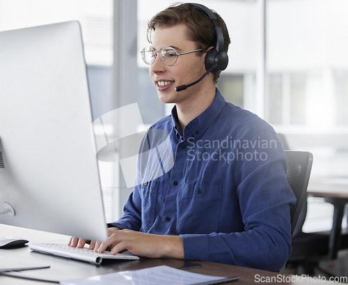 Image of Man, call center and typing on computer, smile in office and working on customer service in workplace. Telemarketing, desktop and happiness of person, male sales agent or consultant consulting online