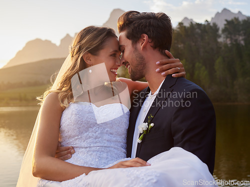 Image of Intimate, love and couple at their wedding by the lake with affection moment together in nature. Happiness, smile and young groom and bride on their romantic outdoor marriage day ceremony by forest.