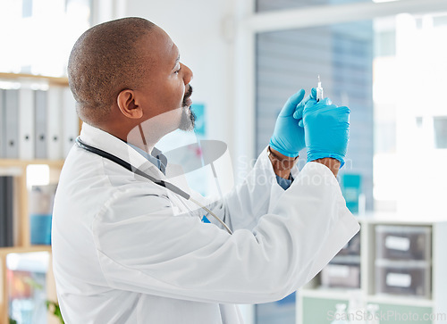 Image of Doctor, syringe and healthcare vaccination, injection or medicine for cure, pain or illness at hospital. Black man, medical professional holding filled needle for wellness or antibiotic at clinic