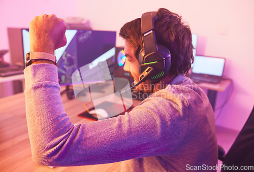 Image of Winner, fist and man on computer with microphone, celebrating game win and success. Happy male gamer, cheering or esport player celebration for online competition, excited for progress or achievement