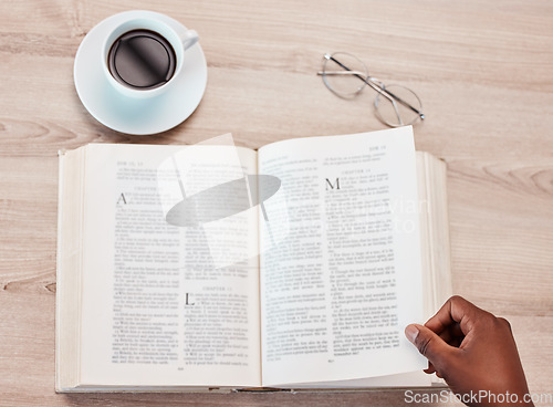 Image of Hand, bible and a person reading in a coffee shop for religion, belief or faith in god and jesus. Education, learning and overhead with an adult in a cafe to study for spiritual knowledge in christ