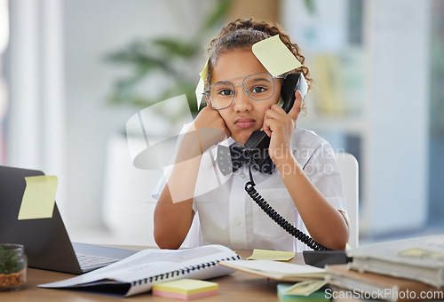 Image of Phone call, boss and child by a desk in the office with sticky notes and a stress, annoyed and upset face. Frustration, landline and girl kid ceo on a telephone while working in a modern workplace.