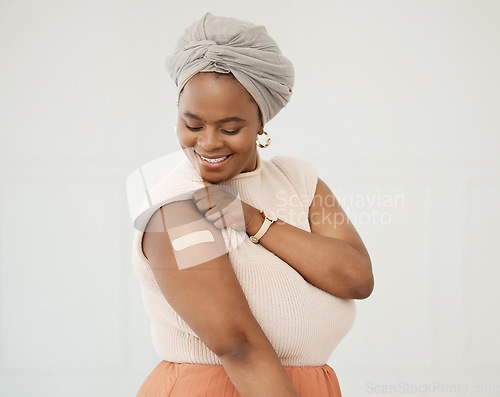 Image of Covid, smile and black woman with plaster on arm in studio for injection on medical insurance. Happy African female on a white background with vaccine, safety compliance and medicine mockup space