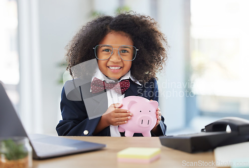 Image of Child, office portrait and piggy bank for saving, finance or investment with smile for playing. Young girl, happiness and bank for future, money and trading at desk in workplace with excited face