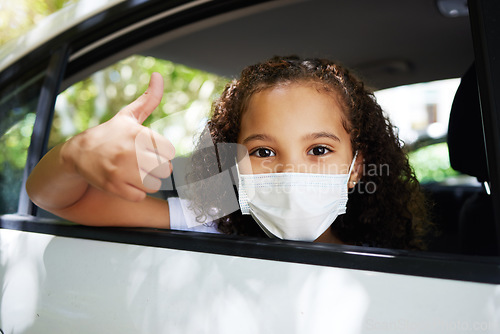 Image of Covid, thumbs up and portrait of a girl in a car for travel, road trip safety and compliance. Free, satisfaction and a little child showing a hand gesture with a face mask for protection in transport