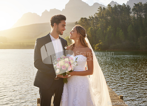 Image of Wedding, couple and lake with a bride feeling love, care and support from marriage together. Nature, happiness and relationship bond of young people with a happy smile from trust and commitment event