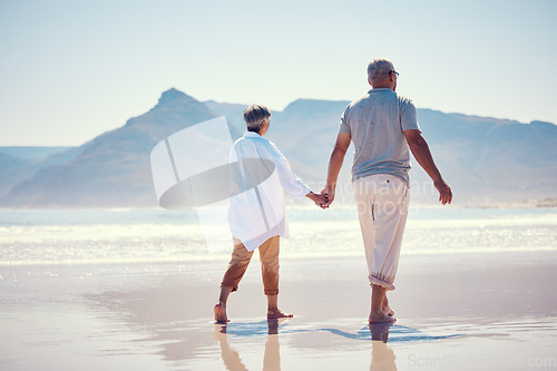 Image of Holding hands, love and an old couple walking on the beach in summer with blue sky mockup from behind. Care, romance or mock up with a senior man and woman taking a walk on the sand by the ocean